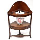An early 20th century mahogany corner washstand with three cut-aways to the top surface,
