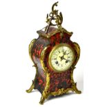A boule mantel clock with an ivorine dial set with Roman and Arabic numerals,