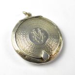 An Edwardian silver pendant compact of circular form with engine turned decoration,