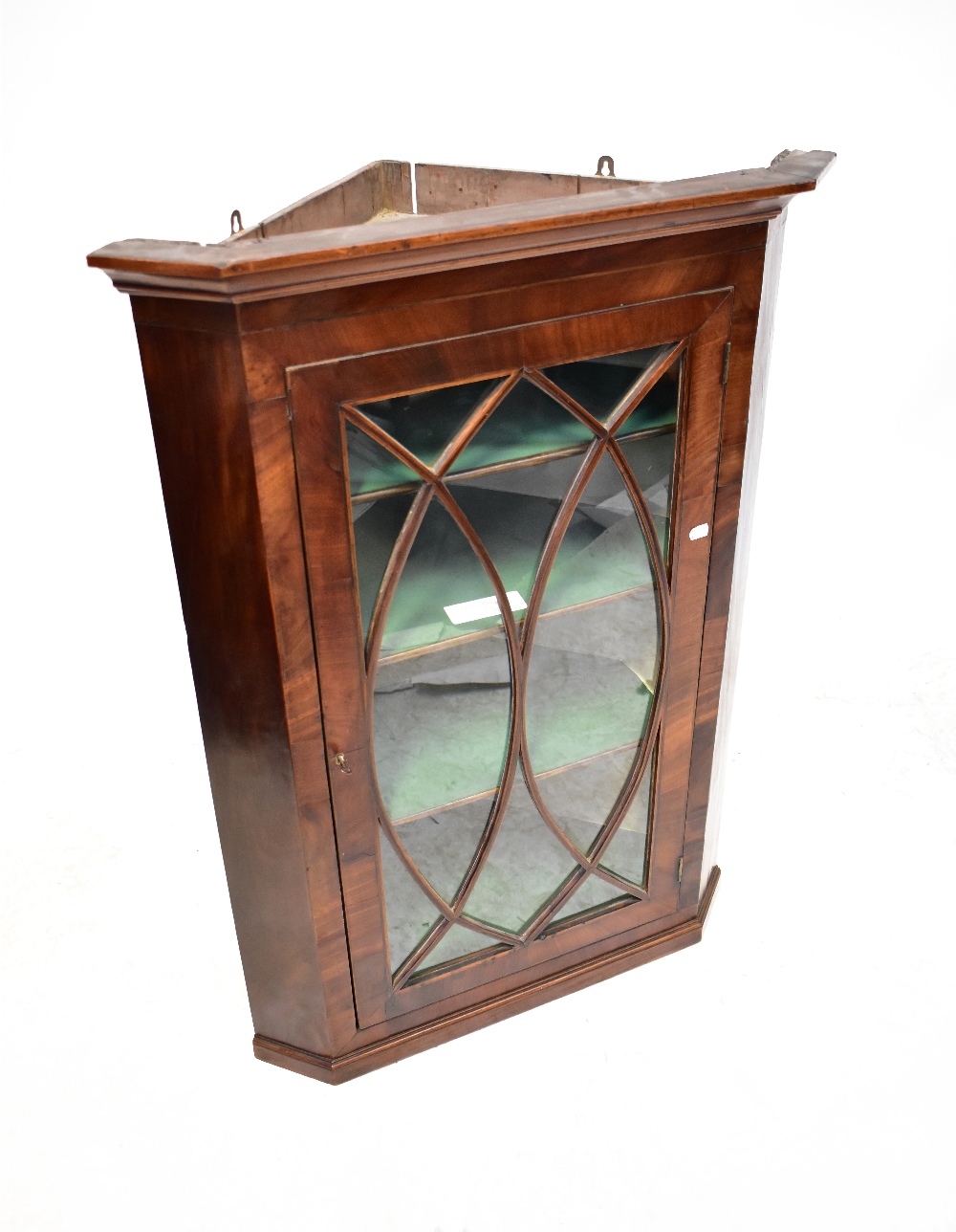 A 19th century mahogany glazed wall-hanging corner cupboard, with astragal oval motif to the door,