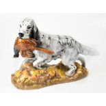 ROYAL DOULTON; a model of a retriever with pheasant in mouth on stylised autumn grassy plinth,