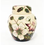 MOORCROFT; a small ginger jar decorated with bramble and white flowers design on an ivory ground,