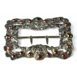 A Victorian silver nurse's buckle with pierced border of Rococo style C-scrolls with cherub heads,