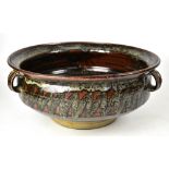 A David Eeles of Shepherds Well Pottery tri-handled bowl of brown ground with mottled band,