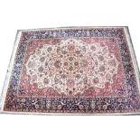 A vintage Persian carpet in blue, cream, red and green,