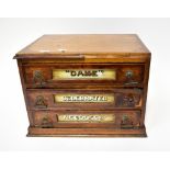 An early 20th century oak haberdashery shop display three-drawer chest,