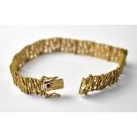 A 9ct gold articulated bracelet with pierced bark form decoration, clasp stamped 375, approx 18.8g.