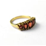 A 9ct gold red stone ring, the five graduated red stones, possibly garnets,
