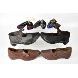 Two pairs of early 20th century clogs, a black pair and a brown pair,