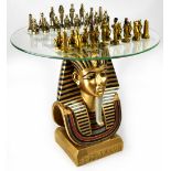 A contemporary chess table, the base in the form of a pharaoh on square plinth with hieroglyphs,