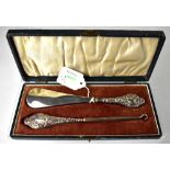 A George V hallmarked silver cased set of button hook and shoehorn,