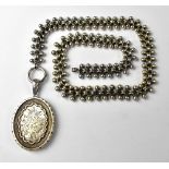 A Victorian hallmarked silver locket with centred panel of floral bouquet,
