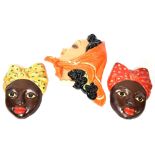 Three 1920s pottery wall-mounted face masks,