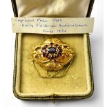 A 19th century Victorian yellow metal brooch with centred collet set cut amethyst,