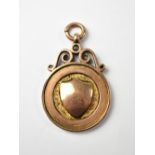 A George V 9ct rose gold prize fob, the circular fob with centred raised blank shield,