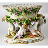 A late 19th/early 20th century Continental porcelain table centre in the form of six putti holding