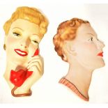 Two Art Deco wall-mounted pottery/plaster wall masks, both depicting the head of an elegant lady,