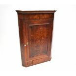 A 19th century oak wall-hanging corner cupboard, with single frieze door,
