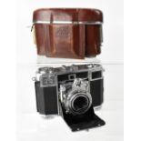 A Zeiss Ikon Contessa folding camera, numbered A31308, within a leather carrying case (case af).
