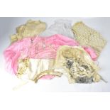 A collection of vintage clothing and textiles to include a cream satin bib overlaid with beaded and