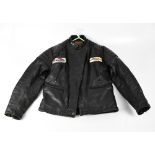 A vintage black leather 'Dominator' bomber jacket with fabric badges for 'Triumph' and 'Harley