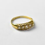 A 18ct gold ring set with five graduated diamonds, within an openwork setting, stamped 18, size L,