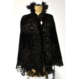 A Victorian black velvet cape embroidered and overlaid with black scrolling foliate and floral