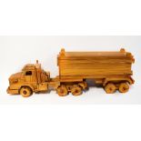 A large wooden model of an articulated lorry, in three separate parts, fitted together on dowels,