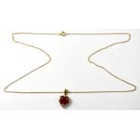 A 9ct gold heart-shaped pendant with claw set centred heart-shaped ruby and a row of four tiny