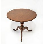 A George III mahogany circular tilt-top occasional table raised on turned central column to three