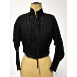 A Victorian black mourning bodice, the collar and chest overlaid with black lace,