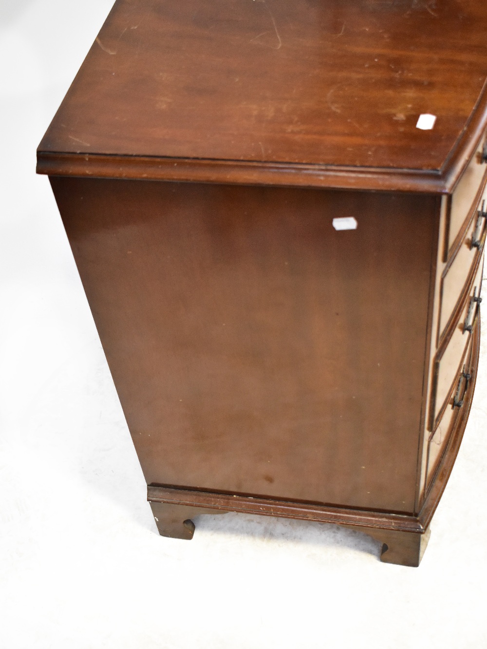 An early 20th century mahogany bow-fronted chest of four graduated drawers, raised on bracket feet, - Bild 4 aus 5