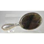 An Edwardian hallmarked silver backed hand mirror, initialled 'ABM' within a beaded border,