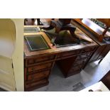 An early 20th century oak pedestal desk with five leather inserts to the top,