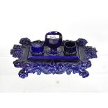 A late 19th/early 20th century ornate pottery desk stand, with central vase-shaped inkwell,