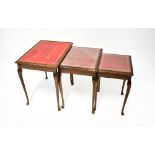 A walnut nest of three tables, with gilt tooled red leather lined tops,