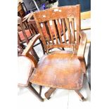 MILWAUKEE CHAIR CO; an early 20th century oak slat back open arm elbow swivel chair,