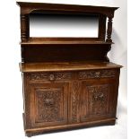 A Victorian carved oak mirror back sideboard, the carved shaped pediment with scrolls and feathers,