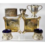 A small collection of silverware comprising a small silver twin-handled trophy,