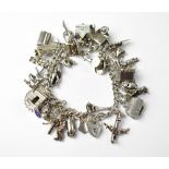 A vintage hallmarked silver charm bracelet, with approximately thirty-seven charms, to include dogs,