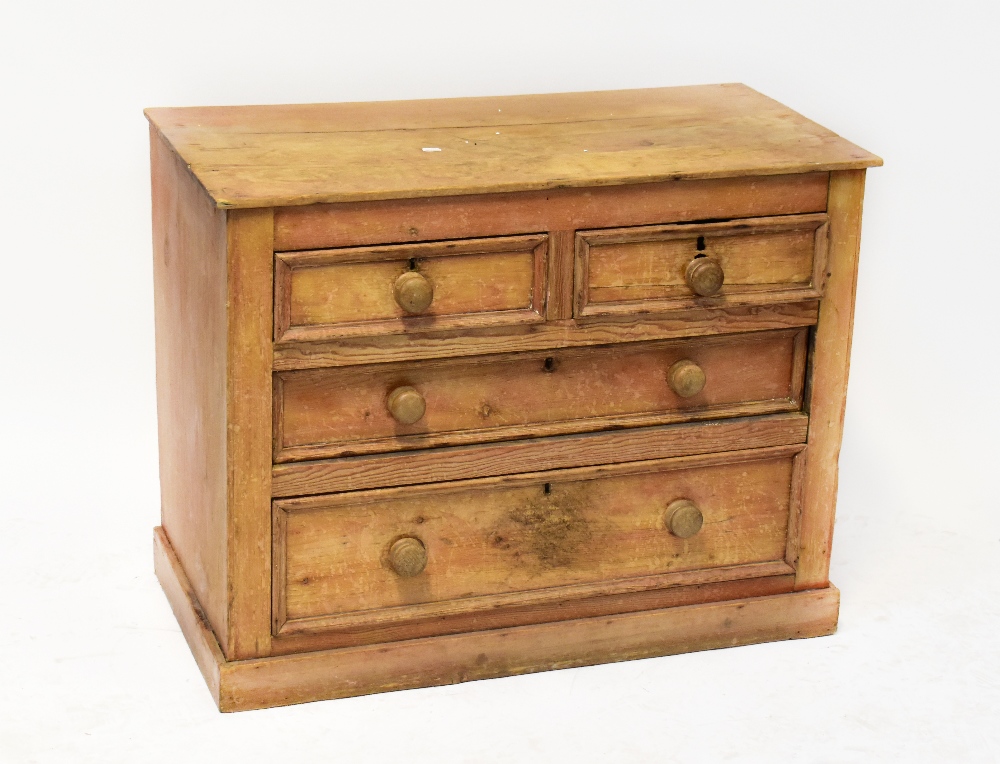 An early 20th century stripped pine chest of two short over two long graduated drawers,