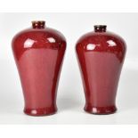 A pair of modern red glaze pottery vases of ovoid form,