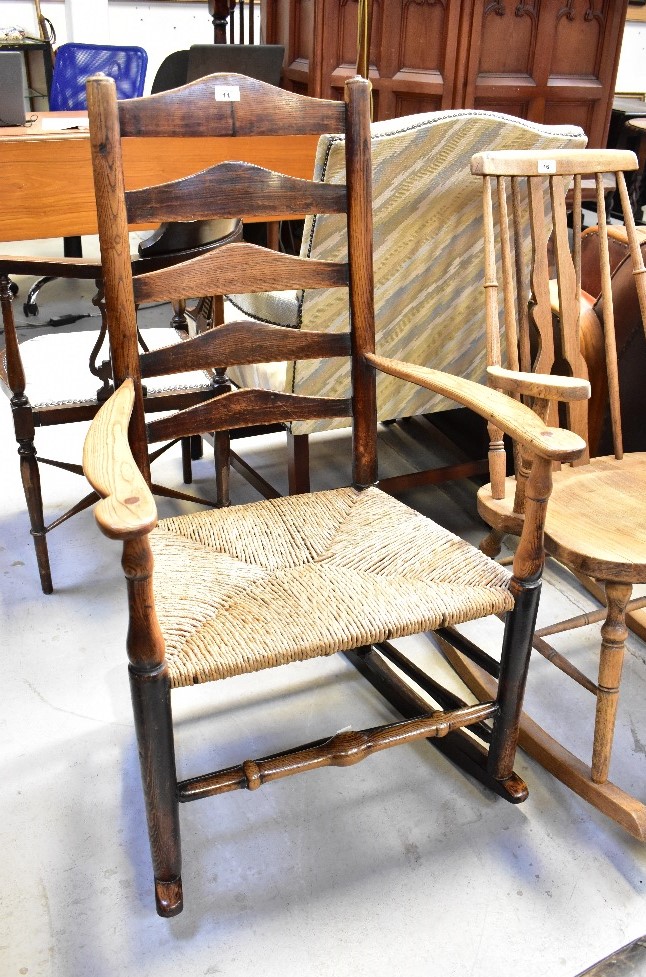 A 19th century or earlier ladder back rocking chair of wide proportions,