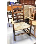 A 19th century or earlier ladder back rocking chair of wide proportions,