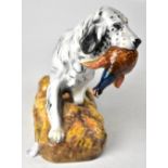 ROYAL DOULTON; a model of a retriever with pheasant in mouth on stylised autumn grassy plinth,