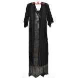 A circa 1930s full-length black silk chiffon beaded dress, with bead trim to the short sleeves,