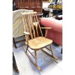 A late 19th/early 20th century stick back rocking chair with shaped arms,