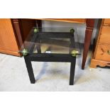 A modern stylised glass top bedside/coffee table,