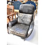 A mid-20th century retro leather upholstered swivel armchair with button back seat,