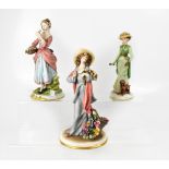 CAPODIMONTE; three figures of ladies, two holding flowers, one signed TYCHE, the other B Merli,